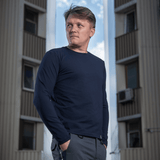 M-Tac Long-sleeve T-shirt 93/7 bæres af mand foran bygning, lavet af 93% bomuld og 7% elastan for holdbarhed og formbevaring.