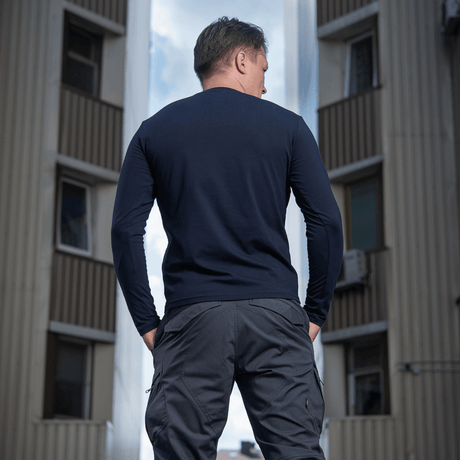 Mand iført M-Tac Long-sleeve T-shirt 93/7 i en byindstilling, viser slidstærk pasform og stilfuldt design