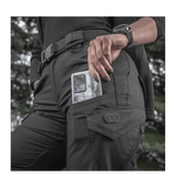 M-Tac Bukser Aggressor Dame Flex med lomme til mobilen, ideelle til træning eller forretningsrejser, fremvist af en kvinde i skoven.