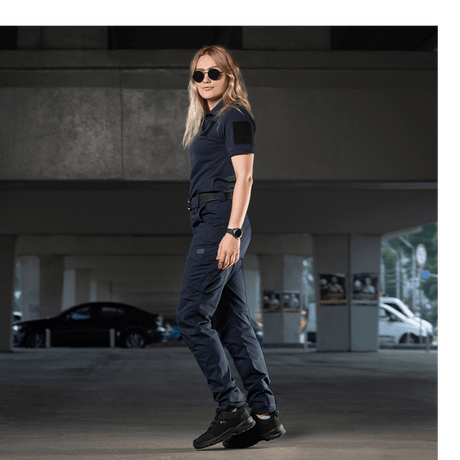 Kvinde iført M-Tac Bukser Aggressor Dame Flex til træning og forretningsrejser, lavet af let materiale med Teflon-impregnering.