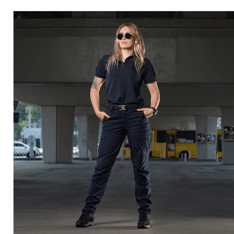 Kvinde iført M-Tac Bukser Aggressor Dame Flex under en bro, klar til træning eller arbejde. Innovative, lette bukser med Teflon.