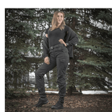 Kvinde iført M-Tac Bukser Aggressor Dame Flex under skovtur, med vand- og smudsafvisende materiale, perfekt til træning og rejser.