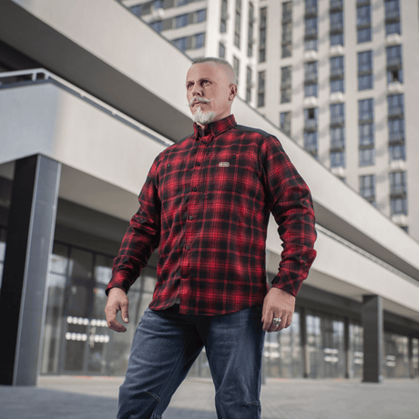 M-Tac Redneck Skjorte i rød-sort plaid på mand i urban baggrund, taktisk design, perfekt til arbejde og fritid.