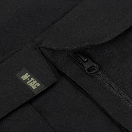 Close-up af M-Tac Bukser STURM NyCo Extreme Gen.II lynlås med M-Tac logo, fremhæver holdbarhed og design.