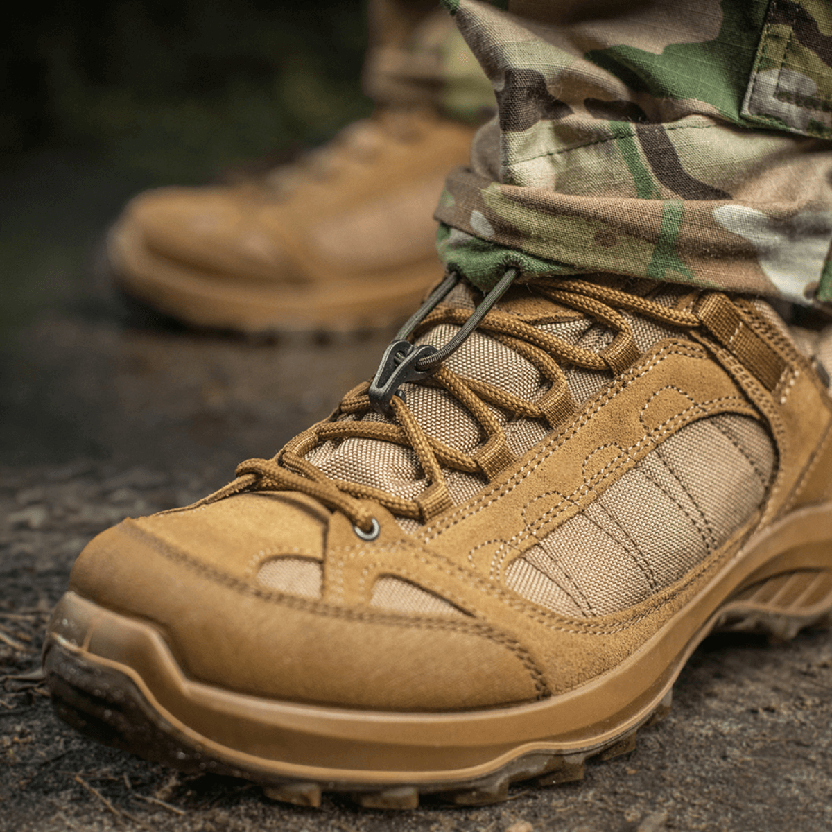 Taktiske støvler og M-Tac Bukser STURM NyCo Extreme Gen.II i aktion udendørs, viser holdbarhed og fleksibilitet i terræn.