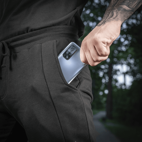 Mand iført M-Tac Shorts Casual Fit Cotton med telefon i lommen, viser brugervenlighed og design.