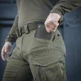 Mand iført M-Tac Bukser Patriot Gen.III Vintage viser lommefunktionalitet udendørs