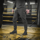 Mand iført M-Tac Bukser Cotton Classic i træningscenter, fremhæver alsidige sportbukser med komfort og stil.