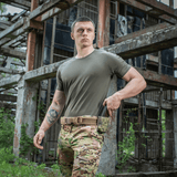 Mand iført M-Tac T-shirt 93/7 Summer i en industriel omgivelse