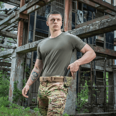 Mand iført M-Tac T-shirt 93/7 Summer i en industriel omgivelse