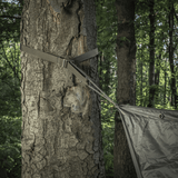 M-Tac Kompressionsrem i brug til fastgørelse af udstyr på et træ, ideelt til vandreture og taktisk brug.