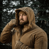 Mand iført M-Tac Division Gen.II Windblock Fleecejakke i skoven, designet til at beskytte mod vind og kulde, meget velegnet til koldt vejr.