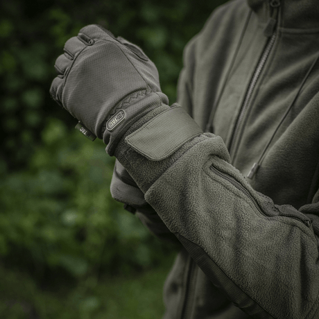 Person iført M-Tac Division Gen.II Windblock Fleecejakke justerer ærmekant i naturmiljø.