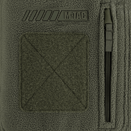 Detalje af M-Tac Division Gen.II Windblock Fleecejakke med logo og lynlås, designet til maksimal varme og beskyttelse mod vind.