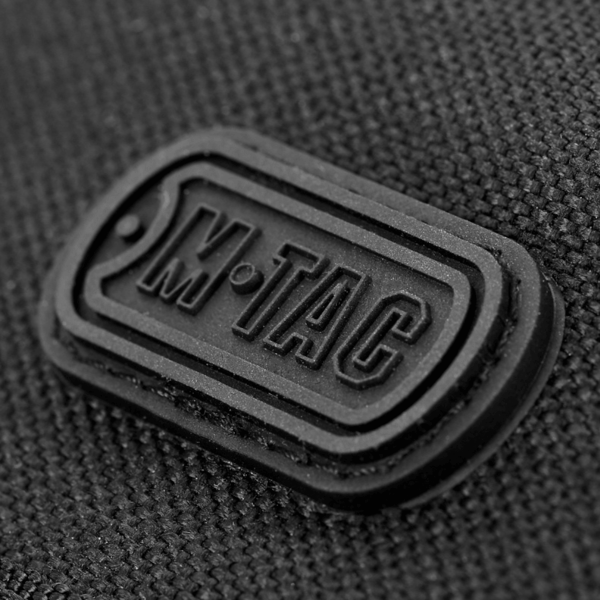 Close-up af M-Tac logo på M-Tac Pung Elite, fremstillet af slidstærkt Cordura nylon, designet i militærstil.