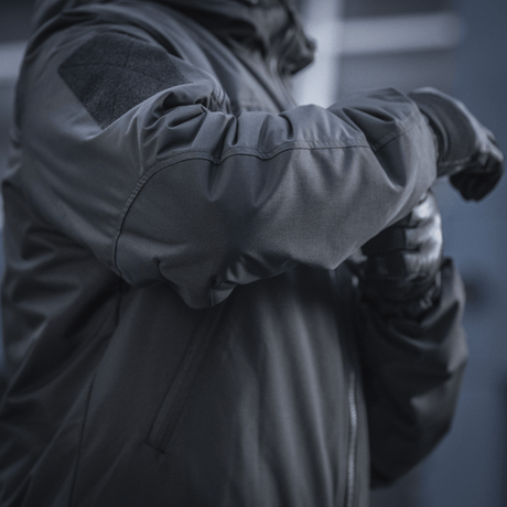 Detaljeret visning af M-Tac Alpha Gen.III Pro Vinterjakke, viser forstærkede albueområder og vandtæt nylonmateriale.