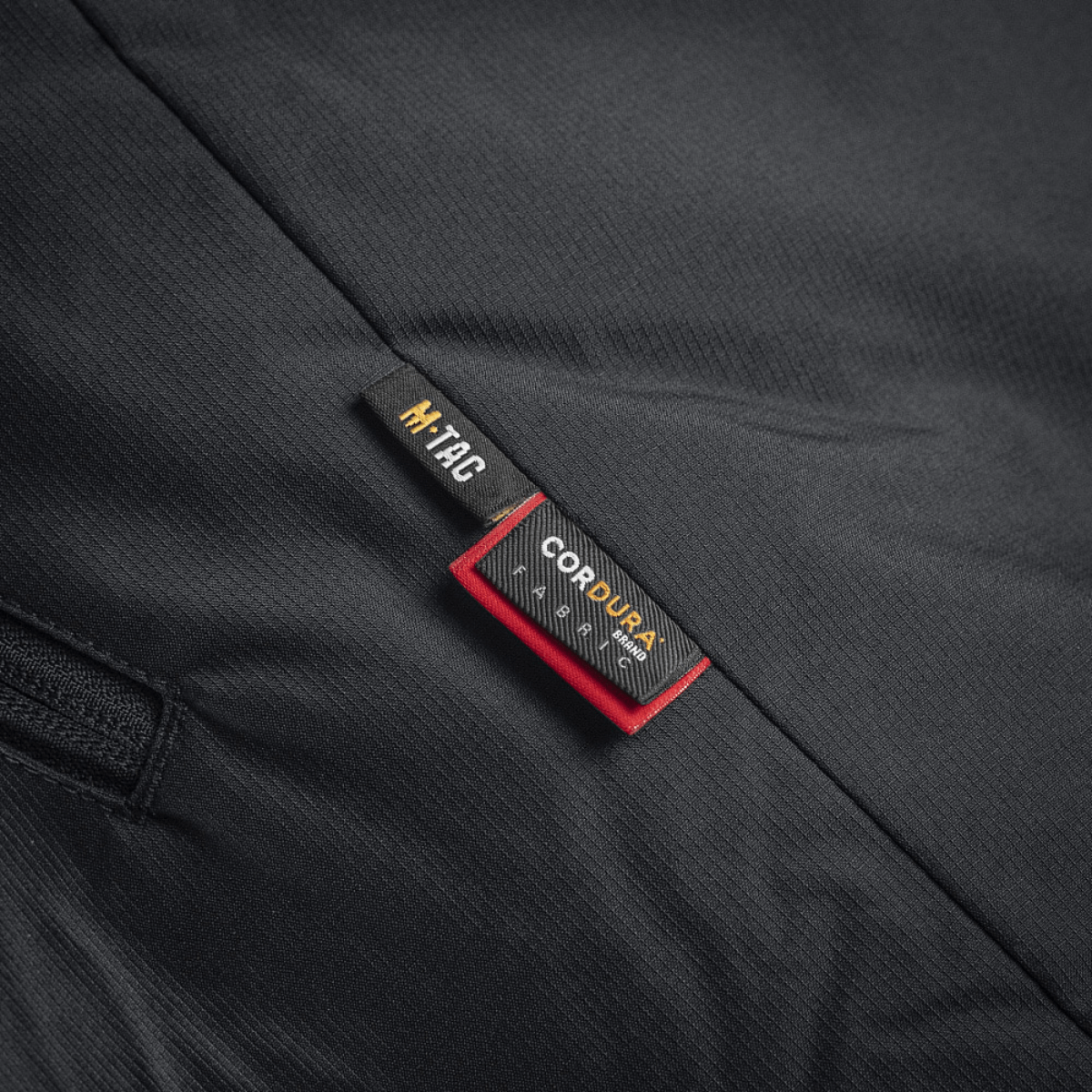 Etiket på M-Tac Alpha Gen.III Pro Vinterjakke med Cordura detaljer i sort stof.