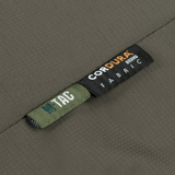 Close-up af M-Tac Alpha Gen.III Pro Vinterjakke med Cordura stofmærke, der fremhæver holdbarhed og kvalitet.