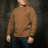 M-Tac Raglan Athlete sweatshirt med rund hals og raglanærmer i coyote, perfekt til sport og daglig brug, set i en industriel setting.