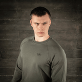 Mand i M-Tac Raglan Athlete sweatshirt i olivenfarve, viser alsidighed og minimalistisk design med raglanærmer for bevægelsesfrihed.