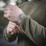 Detaljeret billede af M-Tac Nord Polartec Fleecejakke i brug udendørs, viser kvalitet og tekstur på det grønne fleece materiale.