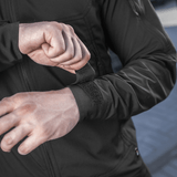 Person iført M-Tac Flash Jakke justerer ærmelukningen, ideel til vandreture og sport. Letvægts med praktisk design uden velcrofelter.