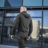 Mand iført sort M-Tac Flash Jakke, perfekt til vandreture og hverdagsbrug, set bagfra foran moderne bygning.