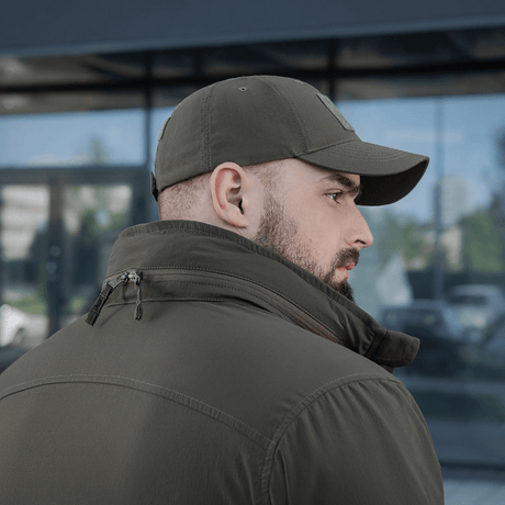 M-Tac Flash Jakke set bagfra, ideel til vandreture og sport, i et praktisk design uden velcrofelter, bæres af en mand med kasket.