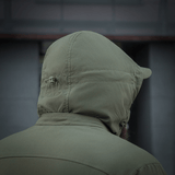 M-Tac Flash Jakke i olivengrøn farve set bagfra med justerbar hætte, ideel til vandreture og aktiv brug i al slags vejr.