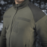 M-Tac Combat Fleece Jakke i grøn farve med vindtætte indsatsstykker, perfekt til udendørs brug og maskinvaskbar.
