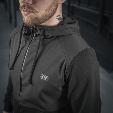 Mand iført M-Tac Pilgrim Bomberjakke, stilfuld og praktisk jakke til sport og hverdag med hætte og lynlåsdetaljer.