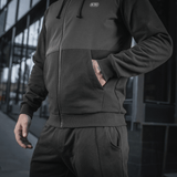 Sort M-Tac Pilgrim Bomberjakke med hætte og ribbede manchetter, ideel til daglig brug og sport. Holdbar kvalitet med central lynlås.