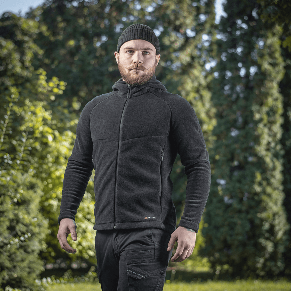 Mand iført M-Tac Sprint Fleece Sweatshirt Polartec i sort, står udendørs foran træer.