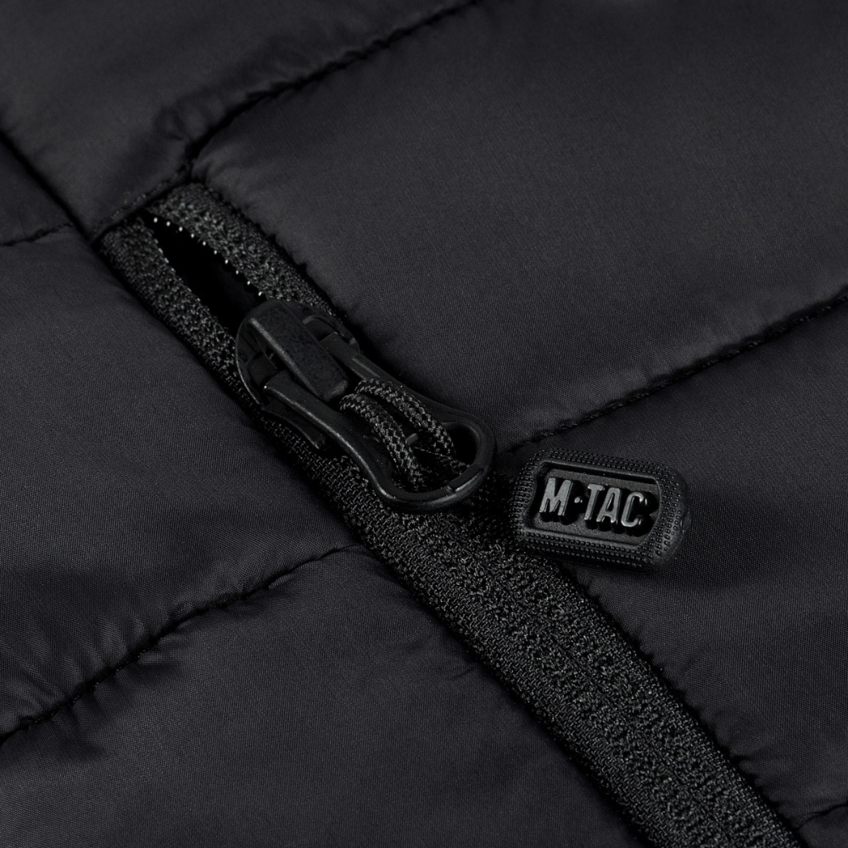 Detalje af M-Tac Stalker Gen.III Jakke med YKK lynlås og M-Tac logo, fokuserer på jakkeens aggressive og moderne design.