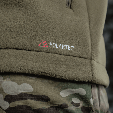 M-Tac Combat Fleece Polartec Jakke med Polartec® logo, tæt detaljeret skud af jakken og kamuflagebukser for taktisk look.