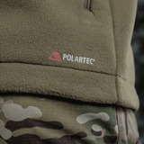 Detalje af M-Tac Combat Fleece Polartec Jakke med Polartec-logo, camouflagemønster og fleece materiale, perfekt til taktisk og casual brug.