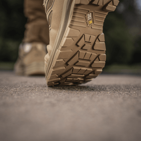 M-Tac Tactical Sneakers IVA i aktion på et udendørs underlag, viser den robuste sål ideel til trekking og outdoor-aktiviteter.