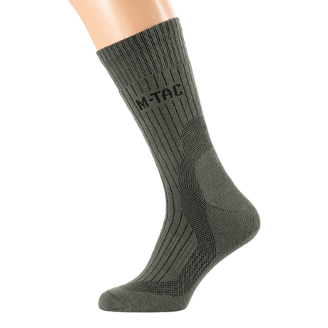 M-Tac Sokker Mid Calf Mk.4 på model, designet til trekking med thermozoner og fodbue-støtte for optimal komfort og beskyttelse.