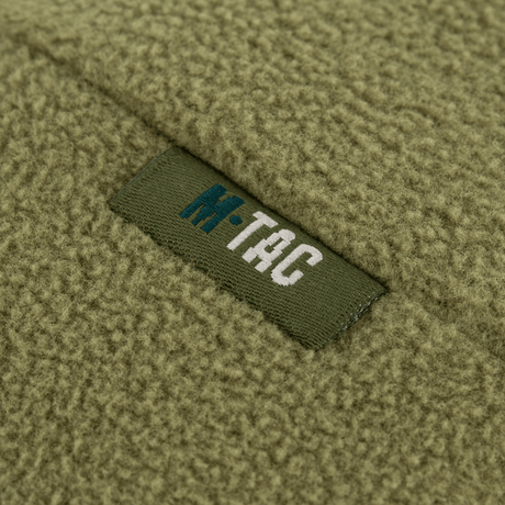Nærbillede af M-Tac Watch Cap Elite Fleece Beanie Hat Slimtex med logo på armygrøn fleece-materiale.