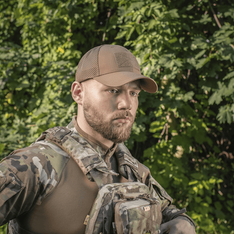 Mand i skov bærer M-Tac Baseball Cap Ripstop Elite Flex og camouflageudstyr