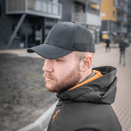 Mand iført M-Tac Mesh Flex Ripstop Baseball Cap med mesh-paneler på fortov, udendørs kasket med justerbar Velcro-strop.