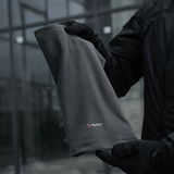 M-Tac Polartec Lang Tubehalstørklæde i gråt fleece, holdt af en person iført handsker. Ideel til koldt vejr og alsidigt brug.