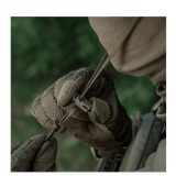 Person iført camouflagetøj justerer et spænde på en M-Tac Panamahat Gen. II Summer Flex i naturmiljø