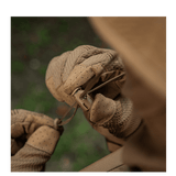 Brune handsker justerer bånd på outdoor-udstyr i naturen