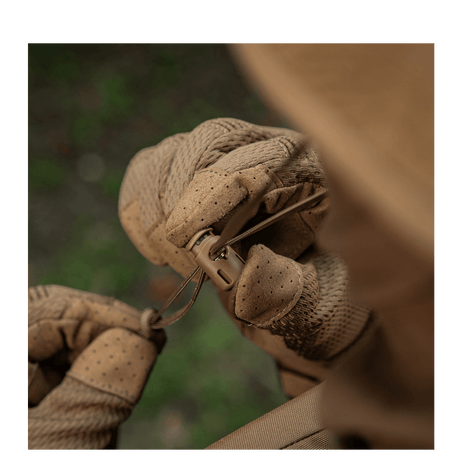 Brune handsker justerer bånd på outdoor-udstyr i naturen