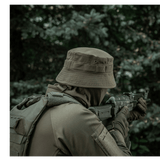 Person iført M-Tac Panamahat Gen. II Summer Flex i en skovmiljø, der demonstrerer solbeskyttelse og komfort