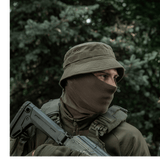 Mand i taktisk udstyr iført M-Tac Panamahat Gen. II Summer Flex i naturen