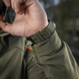 Person wearing M‑Tac Multifunktionelt Taktisk Ur med robust urkasse og rem, ideelt til friluftsliv og militærbrug.