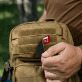 M-Tac Patch Flag 25x80 Mini Squares på en taske, holdt af en person. Cordura 500D, velcro montering, laser cut, slidstærk og let patch.