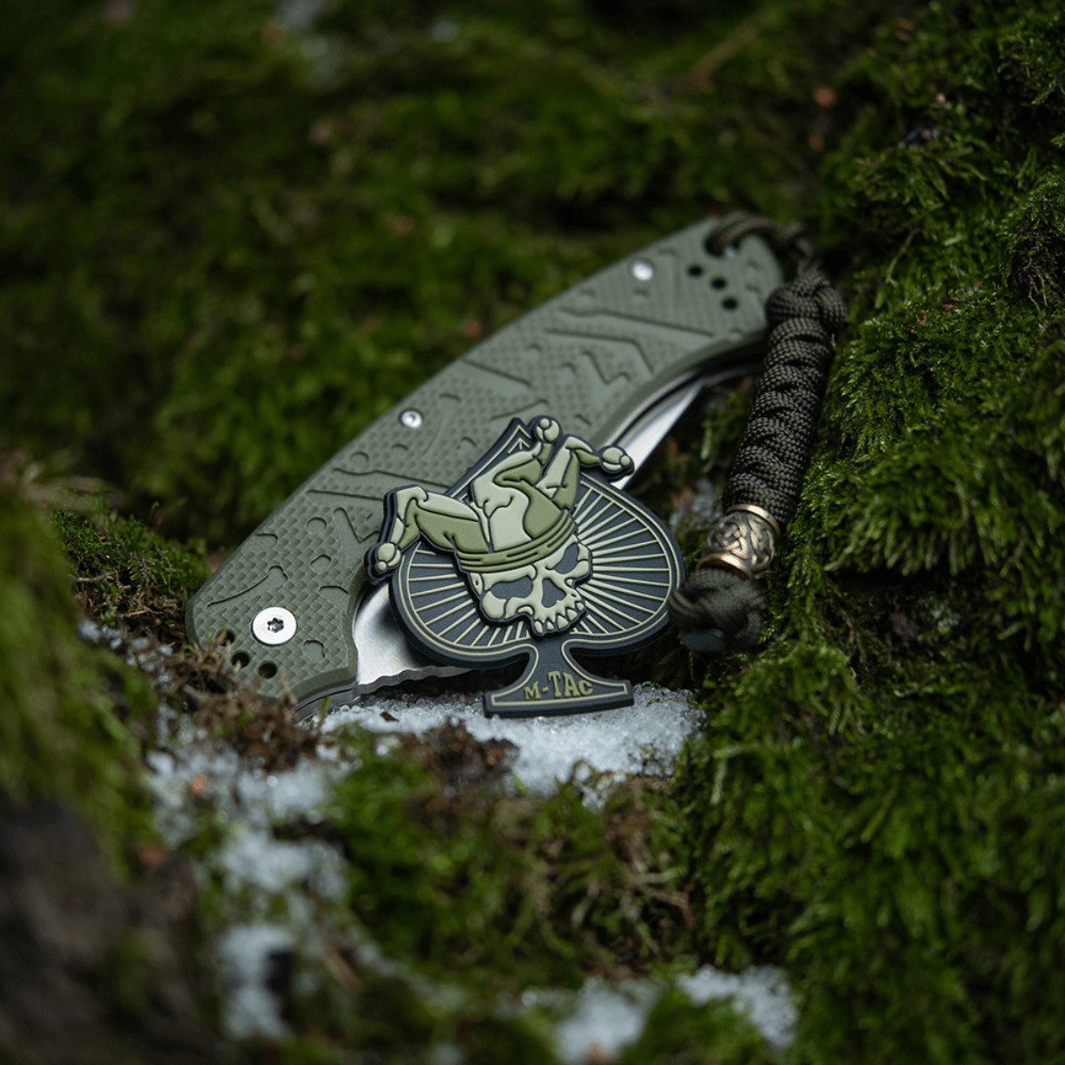 M-Tac Ace of Spades 3D PVC Patch på en grøn baggrund, perfekt til militær og outdoor udstyr som tøj, rygsække og hjelme. Taktisk design.